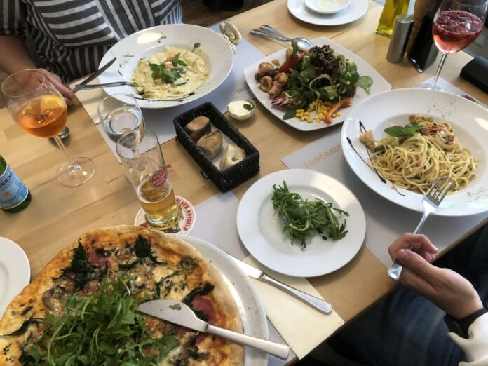 Pizza in Wagenradgröße vom Holzkohlenfeuer